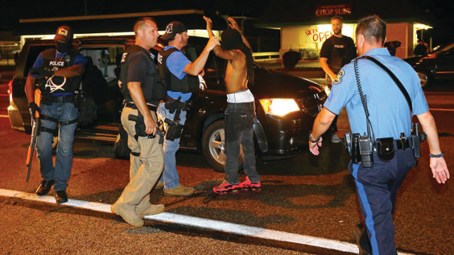 A protester is arrested while walking down the street on West Florissant Avenue on a relatively peaceful night on Aug. 20 in Ferguson, Mo.