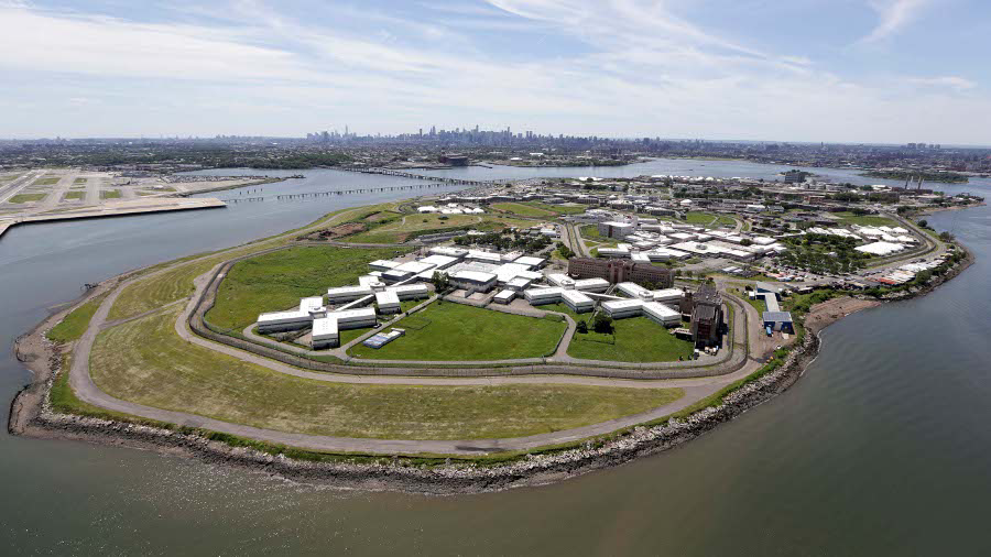 An aerial photo shows New York's biggest lockup, Riker's Island jail, with the New York skyline in the background.