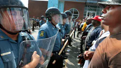 Protestor Boss Bastain of St. Louis locks arms with others as they confront Missouri State Highway Patrol troopers in front of the Ferguson police station on Aug. 11. Protestor Boss Bastain of St. Louis locks arms with others as they confront Missouri State Highway Patrol troopers in front of the Ferguson police station on Aug. 11.
