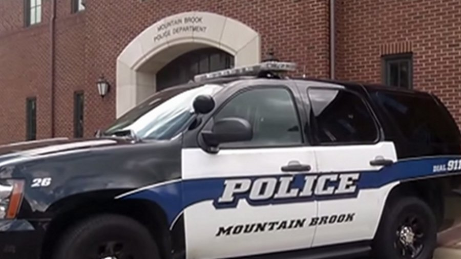 A female jumped out from under a blanket holding an 18-inch long blade swinging at a Mountain Brook police officer's head and neck area, striking him in the arm.