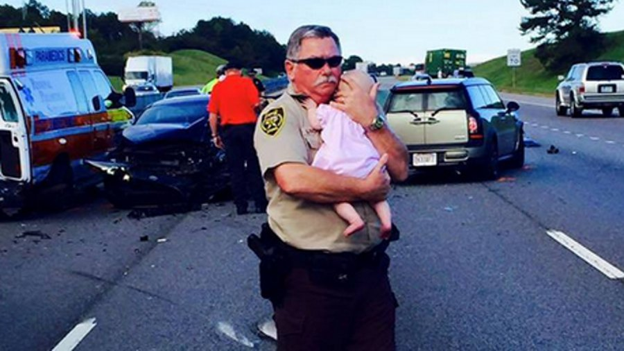 Jefferson County Sheriff's Deputy Ric Lindley is gaining widespread attention after a photo of him holding a baby girl after a crash was posted to Facebook.