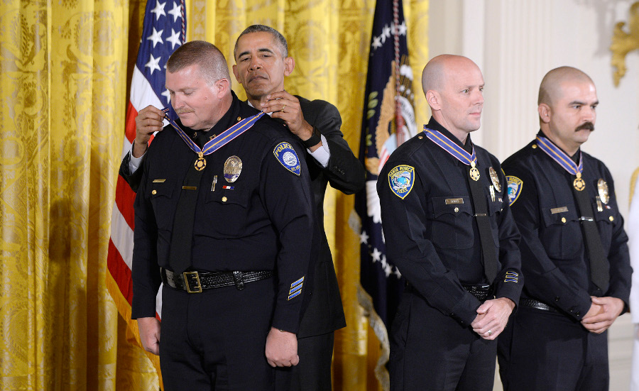 President Barack Obama awards Santa Monica Police Department Officers Jason Salas (R) and Robert Sparks and Captain Raymond Bottenfield (L) with the 2013-2014 Public Safety Office Medal of Valor during a ceremony in the East Room of the White House on May 16 in Washington, D.C.