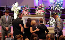 Family members have a moment at the casket at the funeral for detention officer Marianne Johnson on July 22 at the First Baptist Church in Mansfield, Texas. Family members have a moment at the casket at the funeral for detention officer Marianne Johnson on July 22 at the First Baptist Church in Mansfield, Texas.