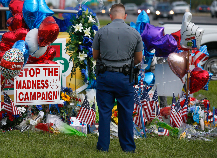 Police officer PJ Freeman stops to pay his respects at the roadside memorial for the three police officers slain in Baton Rouge, La., on July 20.