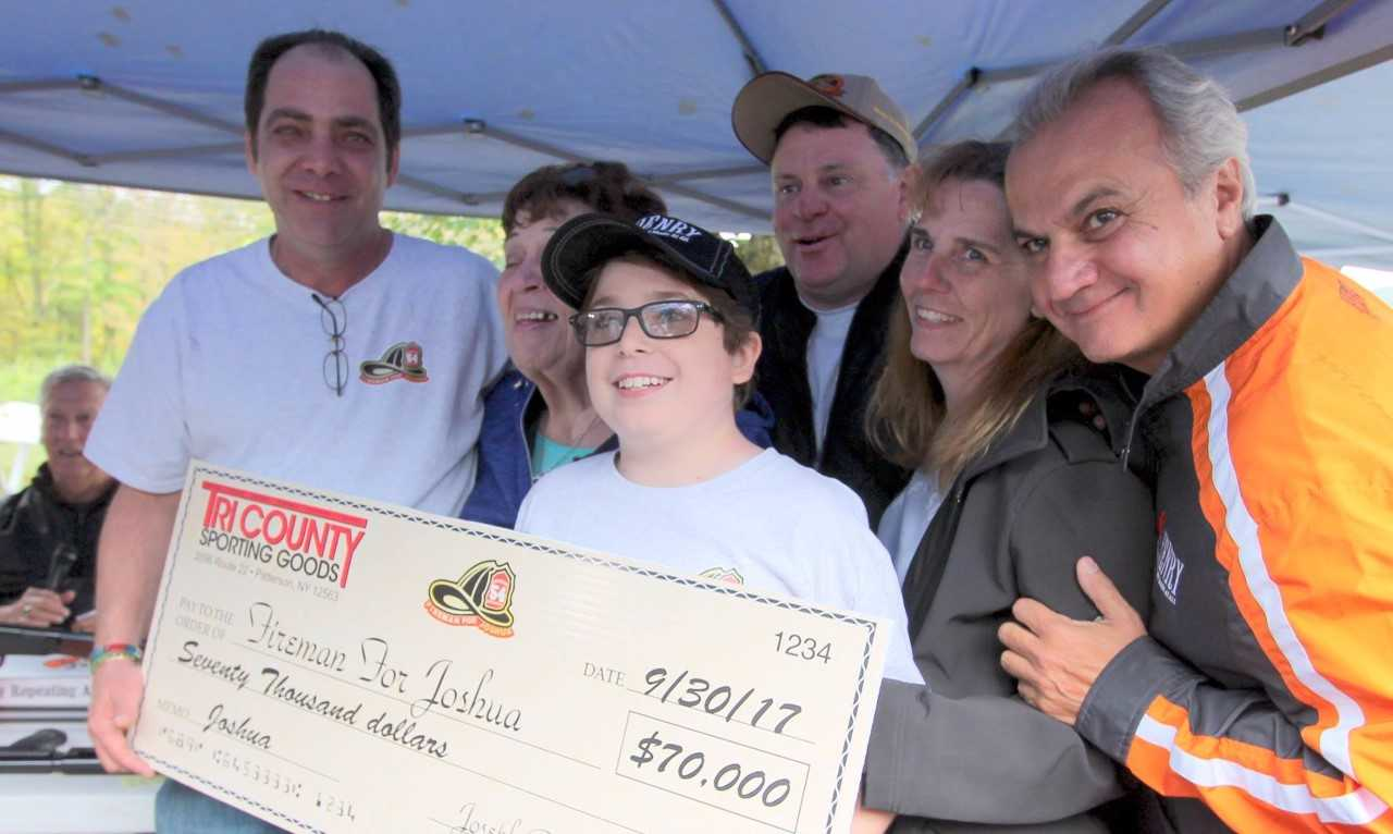 Joe Petrucelli (L), Owner of Tri-County Sporting Goods, presenting check for $70,000 to Joshua Brennan and his family (C) with Anthony Imperato (R), President of Henry Repeating Arms.