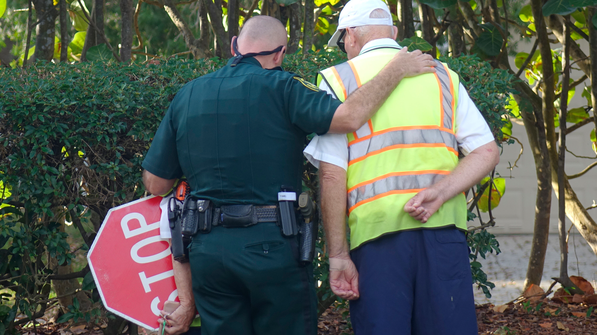 Broward Sheriff Deputy Chris Rossi comforts school crossing guards at Marjory Stoneman High School in Parkland, Thursday, Feb. 15, 2018.