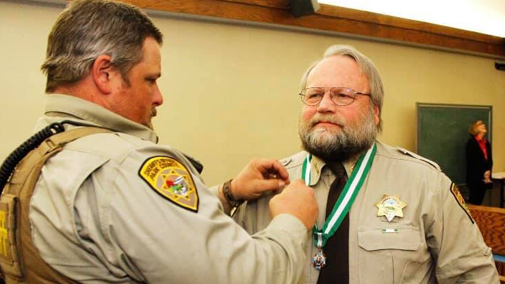 Park County Sheriff's Deputy Brian Elliott-Pearson is seen receiving a Meritorious Service medal for saving a life in 2015.