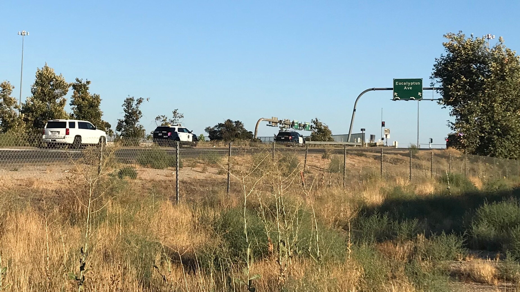 Police are seen near the Eastridge Avenue exit of the 215 Freeway where a wild shootout occurred on Monday, Aug. 12, 2019.