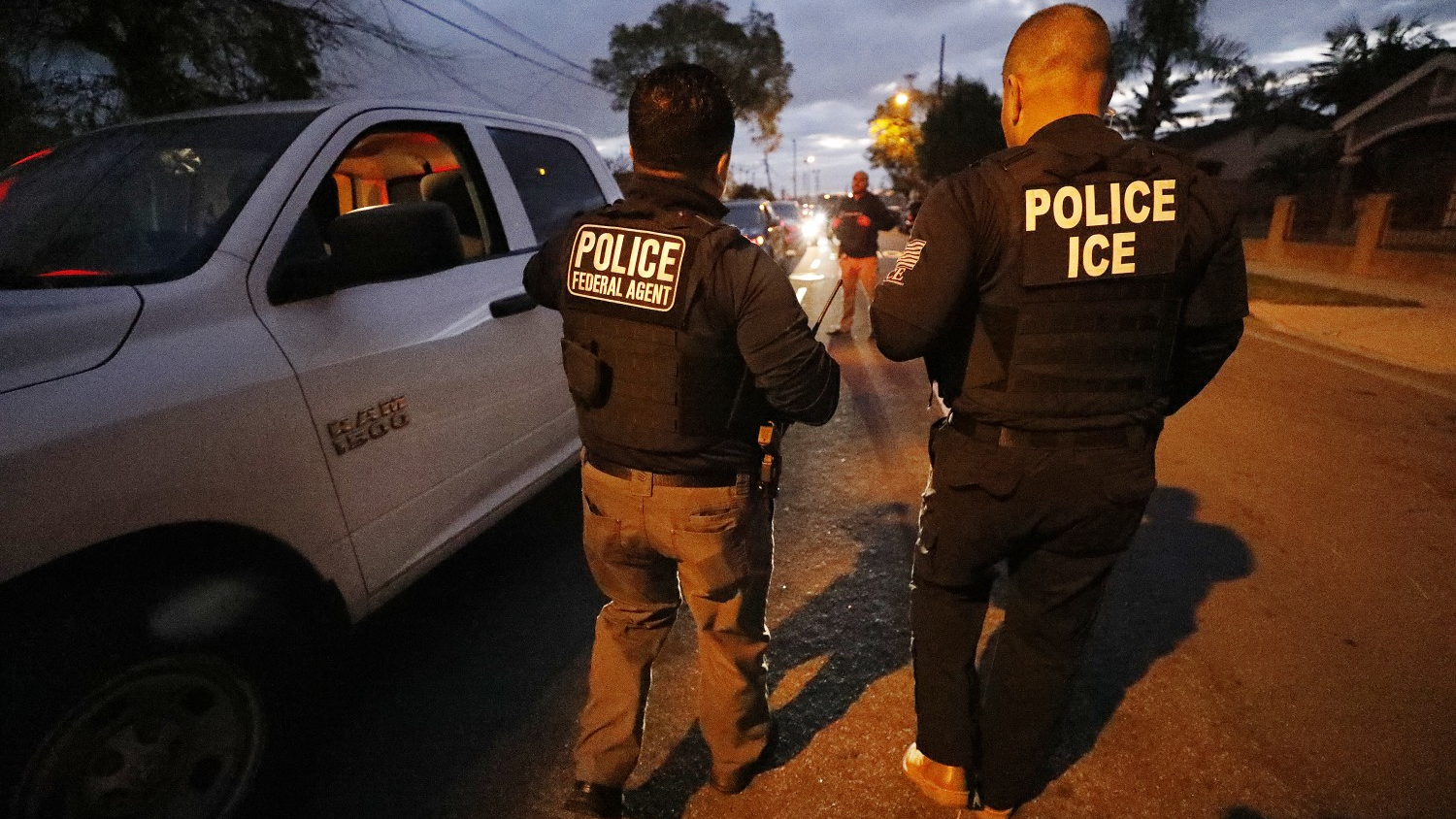 David A. Marin (right), field office director of enforcement and removal operations for the Los Angeles branch of U.S. Immigration and Customs Enforcement, works during a pre-dawn apprehension in Bell Gardens, CA, as ICE officers are joined by U.S. Customs & Border Protection agents in sanctuary cities.