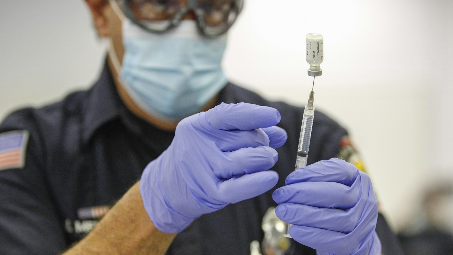 Firefighter-paramedic Mitch Mendler prepares a Pfizer COVID-19 vaccine for a recipient at the San Diego Fire-Rescue Training Facility on Dec. 31.