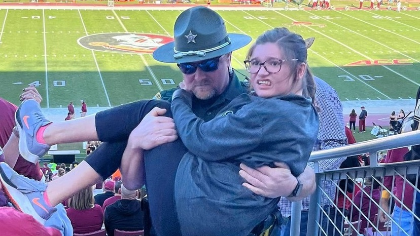 A Leon County, FL, sheriff's deputy carried a young woman struggling to reach her seat during the Florida State-Miami game Nov. 13 at Doak Campbell Stadium in Tallahassee.