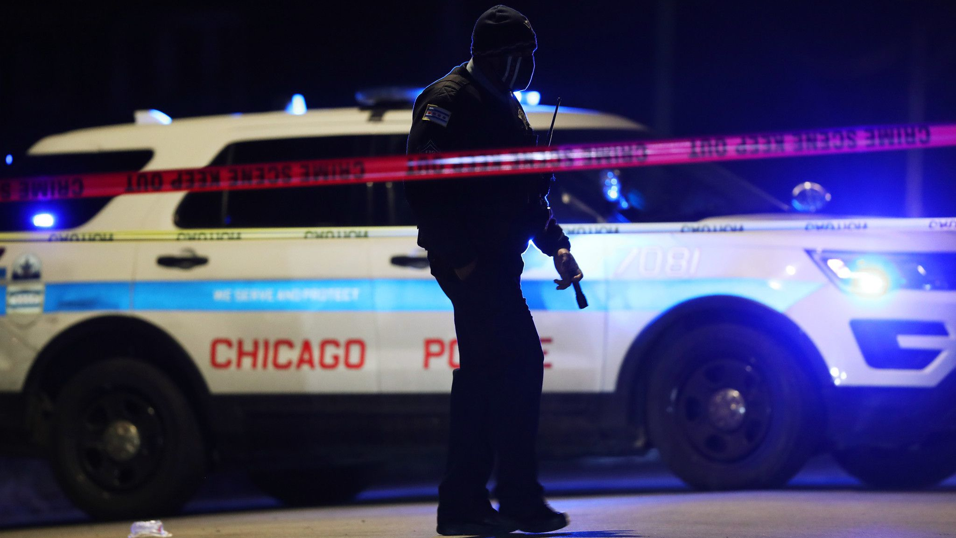 A Chicago police officer walks past a puddle of blood at the scene of a fatal shooting Friday. An 18-year-old male was shot in the neck by an unknown offender, according to police.
