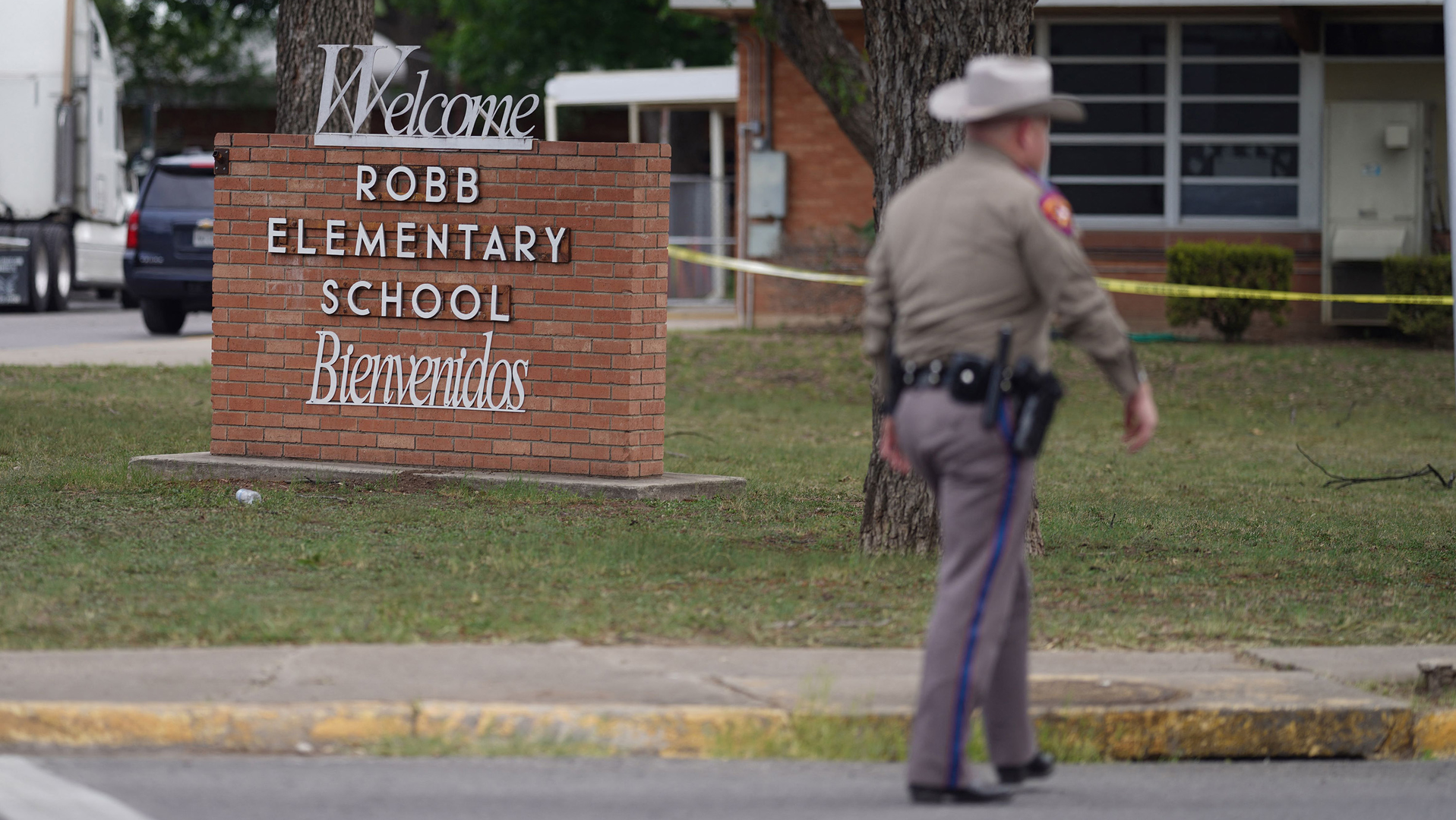 An officer walks outside of Robb Elementary School in Uvalde, TX, on Tuesday after an 18-year-old gunman killed 19 children and two adults at the school in the nation's deadliest school shooting in years.