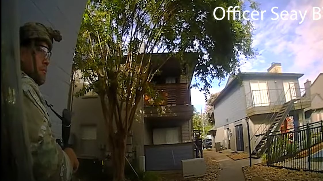 Houston police officers wait outside an apartment complex during a six-hour standoff in June with a suspect accused of shooting and wounding an officer in both legs.