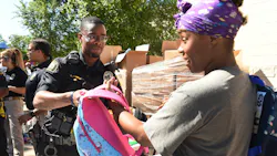St. Paul, MN, Police Officer Lorenzo Lamb hands a backpack to Demetria Smith at the second annual Barbers & Backpacks event Tuesday at St. Paul's Conway Recreation Center. The event is sponsored by the Minnesota Chapter of the National Black Police Association. St. Paul, MN, Police Officer Lorenzo Lamb hands a backpack to Demetria Smith at the second annual Barbers & Backpacks event Tuesday at St. Paul's Conway Recreation Center. The event is sponsored by the Minnesota Chapter of the National Black Police Association.