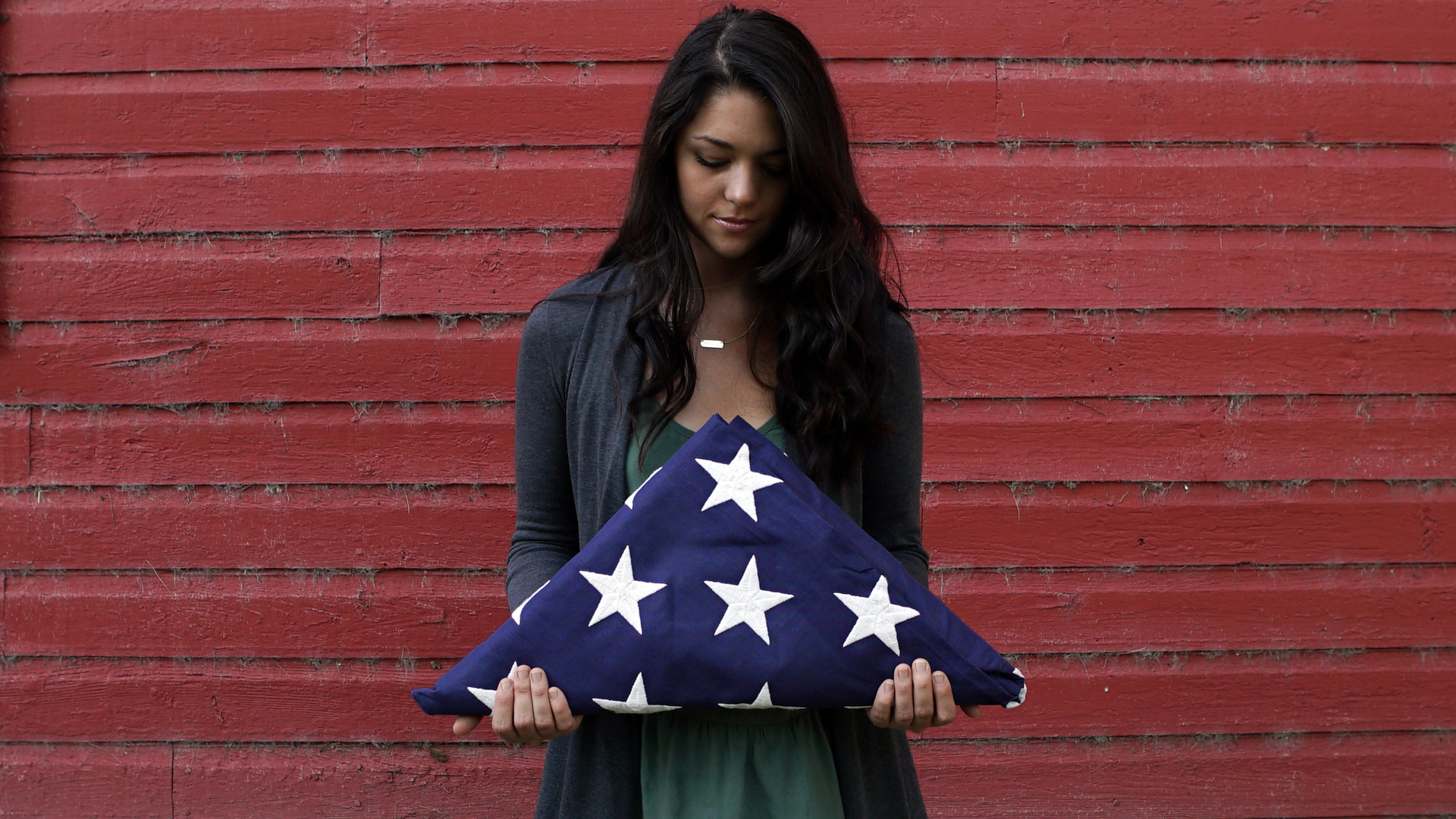 Folds of Honor scholarship recipient, Tayler Garber, holding a folded American flag.