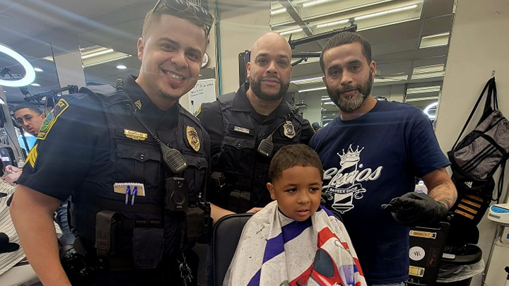 A young man receives a trim as part of East Hartford, CT, Police Department's Haircut With a Cop program Monday.