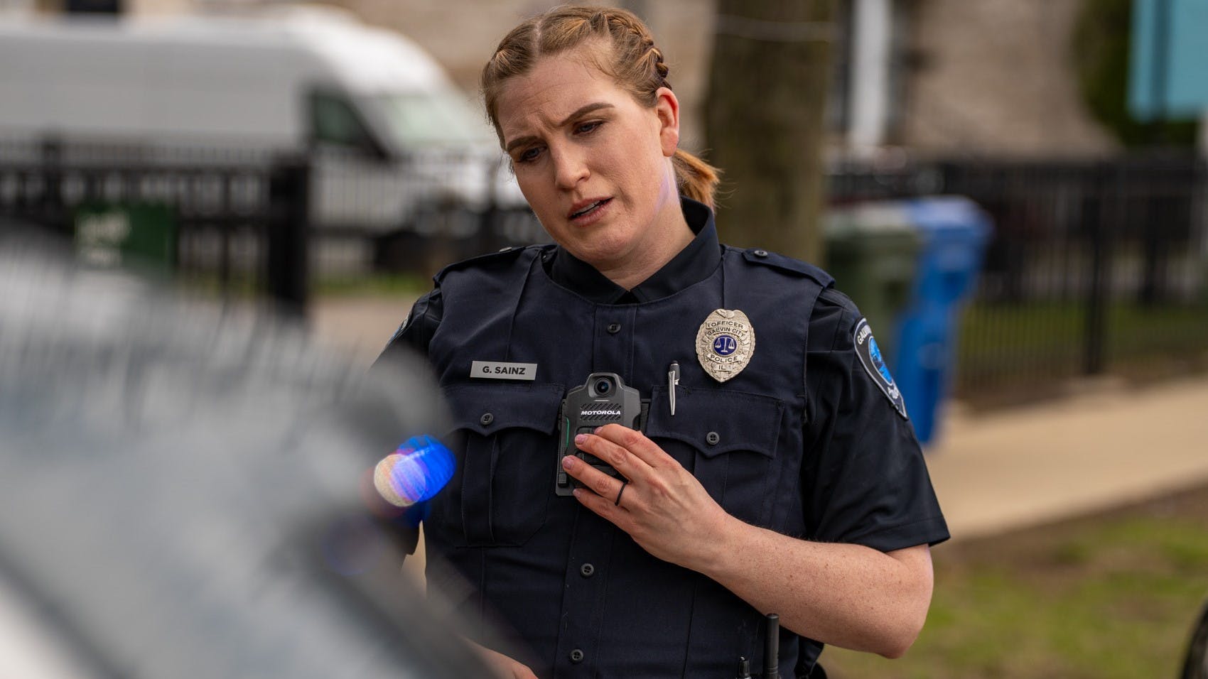 An officer is seen wearing a Motorola Solutions SVX Remote Speaker Microphone enabled with Assist.