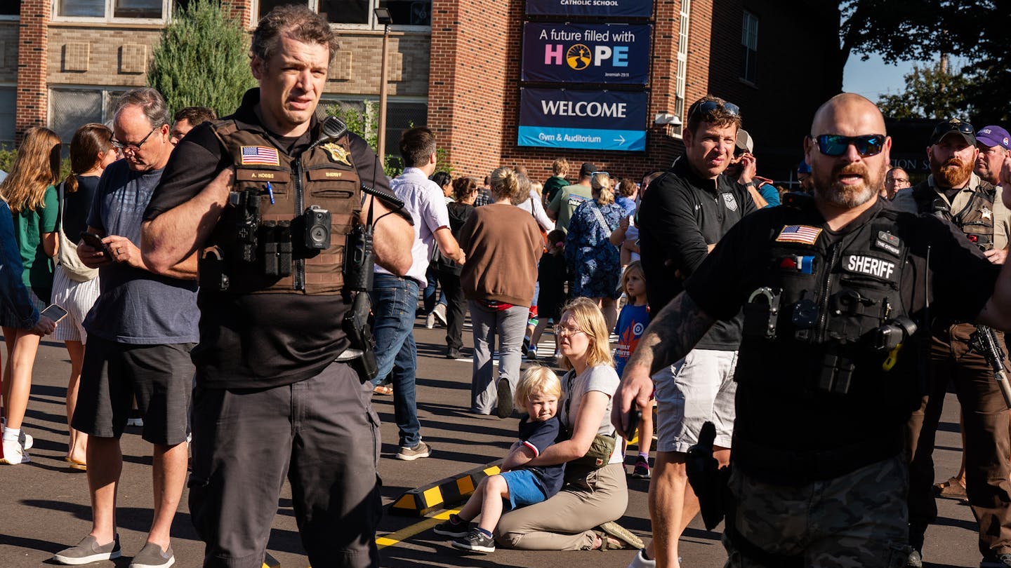 Minneapolis police officers work to contain the scene during an active shooter situation at the Annunciation Church on Wednesday.
