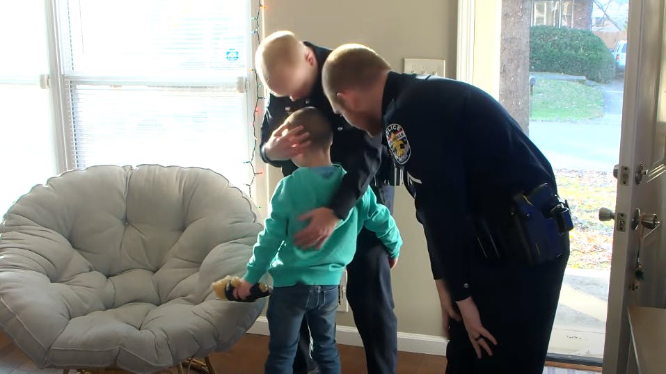A Louisville, KY, police officer receives a hug last month from the boy he helped rescue from a burning home in March.