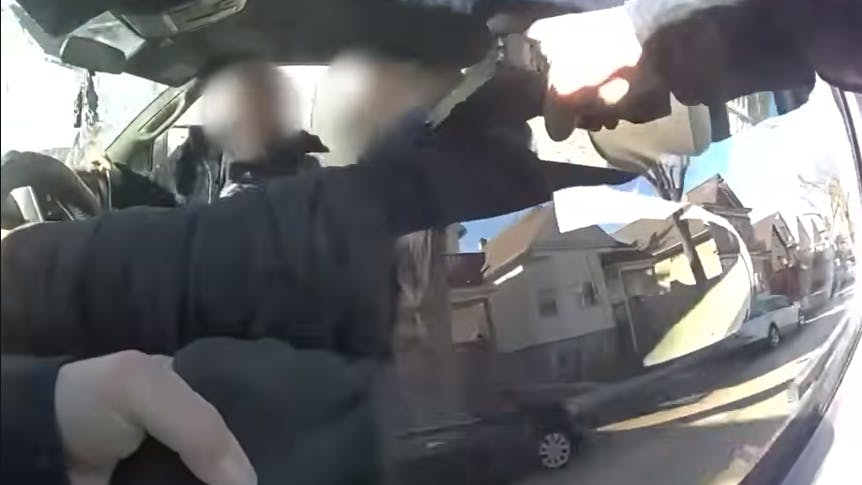 Milwaukee Police Officer clings to tow truck before fatally shooting suspect.