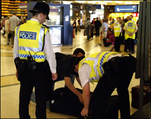 British Transport Police search the luggage of a passenger at King's Cross station, in London, Monday, July 11, 2005. Security has been stepped up in the wake of last Thursday's attacks on London's transport system.
