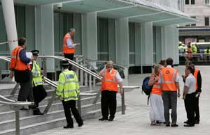 London Underground staff and police officers stand outside evacuated Warren Street station in central London.