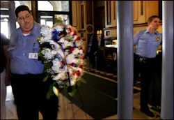 Illinois Secretary of State security guard Carl Faust, left, carries a wreath of flowers around the metal detector at the north entrance of the Illinois state Capitol in Springfield, Ill. He is joined by Mitch White of ELA Security, who is working the fac Illinois Secretary of State security guard Carl Faust, left, carries a wreath of flowers around the metal detector at the north entrance of the Illinois state Capitol in Springfield, Ill. He is joined by Mitch White of ELA Security, who is working the fac