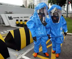 Firefighters wearing protection suit prepare to proceed into the Singapore embassy, background, after the embassy received a suspicious large envelope addressed to the ambassador, bearing a postmark from Malaysia's northeastern Kelantan state in Kuala Lum Firefighters wearing protection suit prepare to proceed into the Singapore embassy, background, after the embassy received a suspicious large envelope addressed to the ambassador, bearing a postmark from Malaysia's northeastern Kelantan state in Kuala Lum
