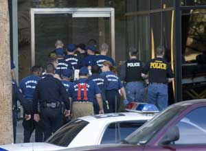 Police, and medical personnel from the fire department, enter a Phoenix high-rise Thursday, Feb. 23, 2006. A gunman held up to nine people hostage Thursday in an office in the building, a police spokesman said. Sgt. Andy Hill said everyone was inside a he