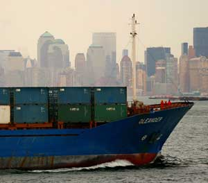 A container ship passes the New York skyline. Cargo container examination standard operating procedures and a timeline for radiation portal monitors at U.S. ports are part of a new port security bill proposed by two House Republicans.