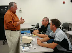 Bob Donovan (left), who reps ProTech, explains business opportunities of the ProTech technology to ADI Elk Grove Village inside sales reps Juan Garcia (seated, background) and Bill Behrens (seated, foreground) during the Outdoor Perimeter Protection Week. Bob Donovan (left), who reps ProTech, explains business opportunities of the ProTech technology to ADI Elk Grove Village inside sales reps Juan Garcia (seated, background) and Bill Behrens (seated, foreground) during the Outdoor Perimeter Protection Week.