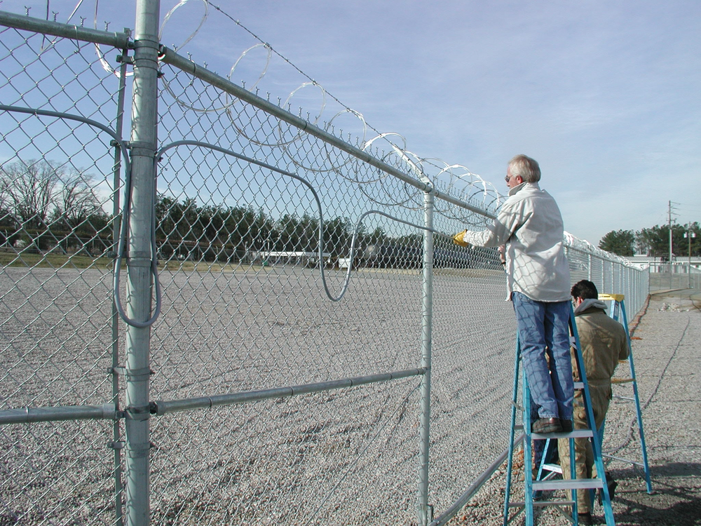 Integrators install detection on a perimeter fence.