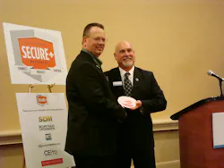 Mike Miller of Moon Security receives a SECURE+ award from Kirk MacDowell, residential business leader, Interlogix and SECURE+Task Force Chair. Mike Miller of Moon Security receives a SECURE+ award from Kirk MacDowell, residential business leader, Interlogix and SECURE+Task Force Chair.