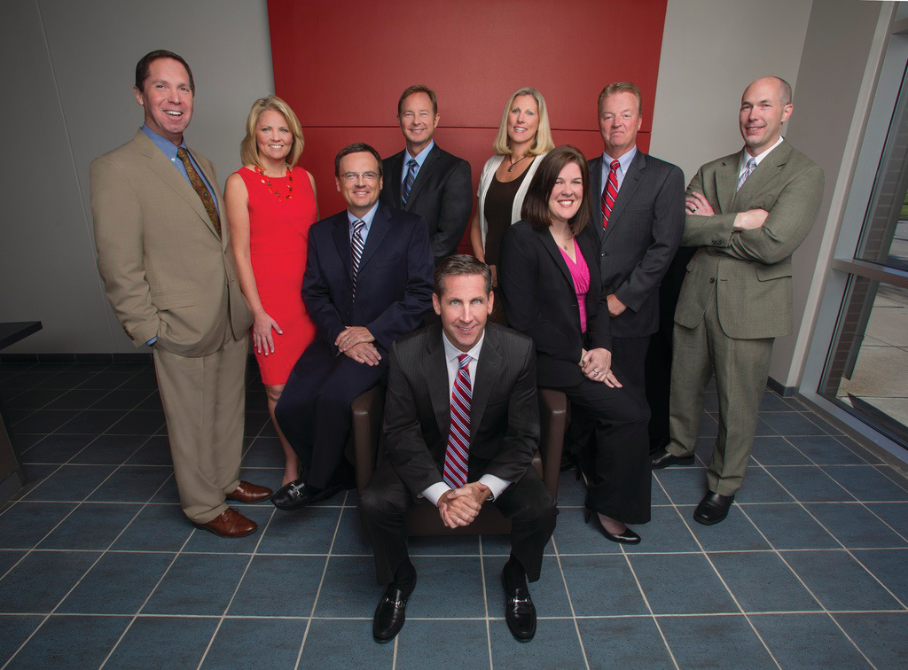 Protection 1 Chairman and CEO Tim Whall, center, surrounded by the company's leadership team.