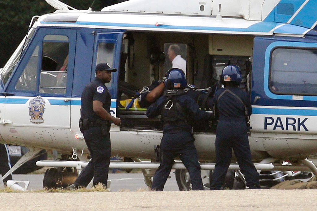 A U.S. Park Police helicopter is loaded on the Mall in Washington, Thursday, Oct. 3, 2013, with a victim from a shooting. Police say the U.S. Capitol has been put on a security lockdown amid reports of possible shots fired outside the building.
