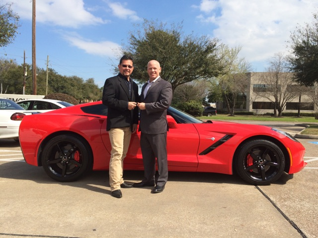 John Sullivan (right), senior vice president of sales at ADI, hands over the keys to a new Chevy Corvette to Ricky Gonzalez, owner of ACI Telephones in Houston TX.