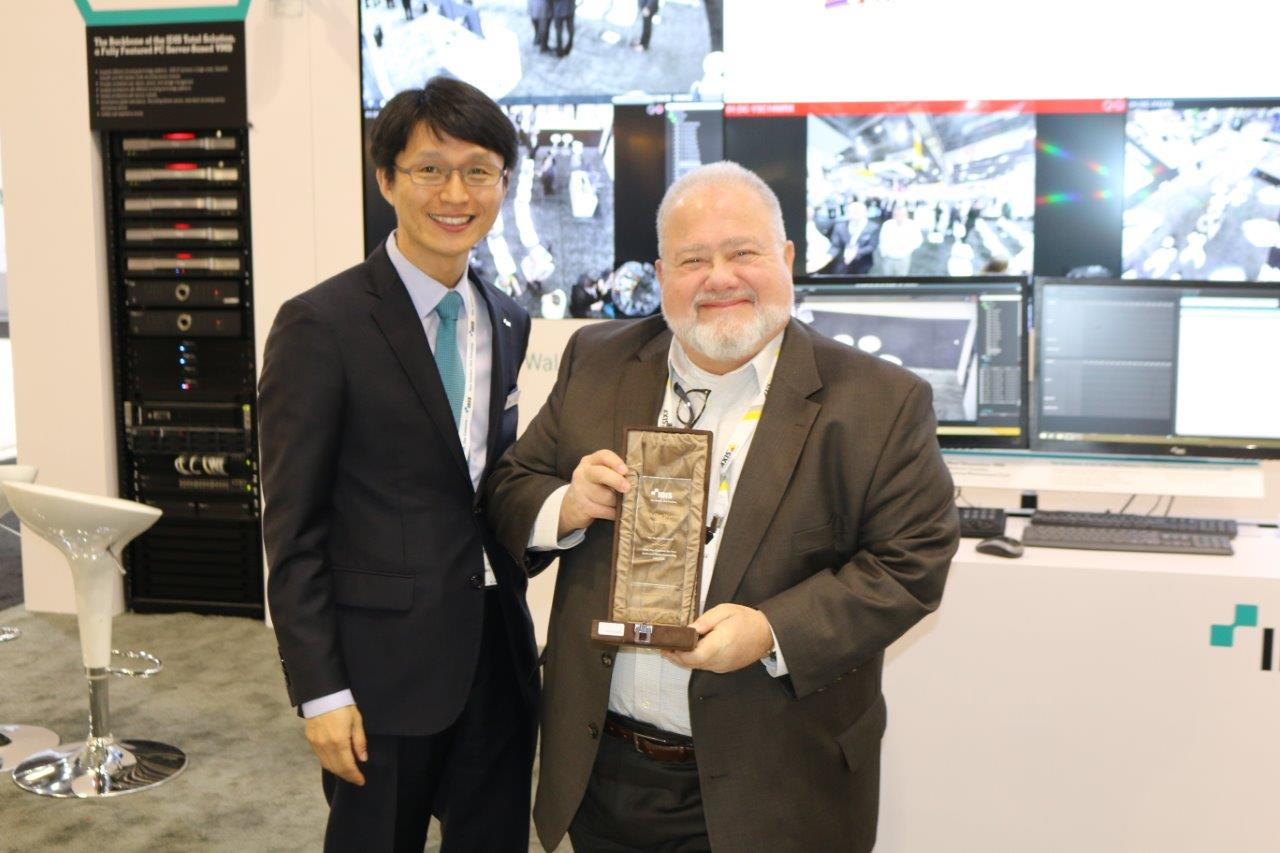 Southcomm Security Media Editorial Director Steve Lasky accepts an award honoring the company's media support from IDIS president Dr. Albert Ryu.