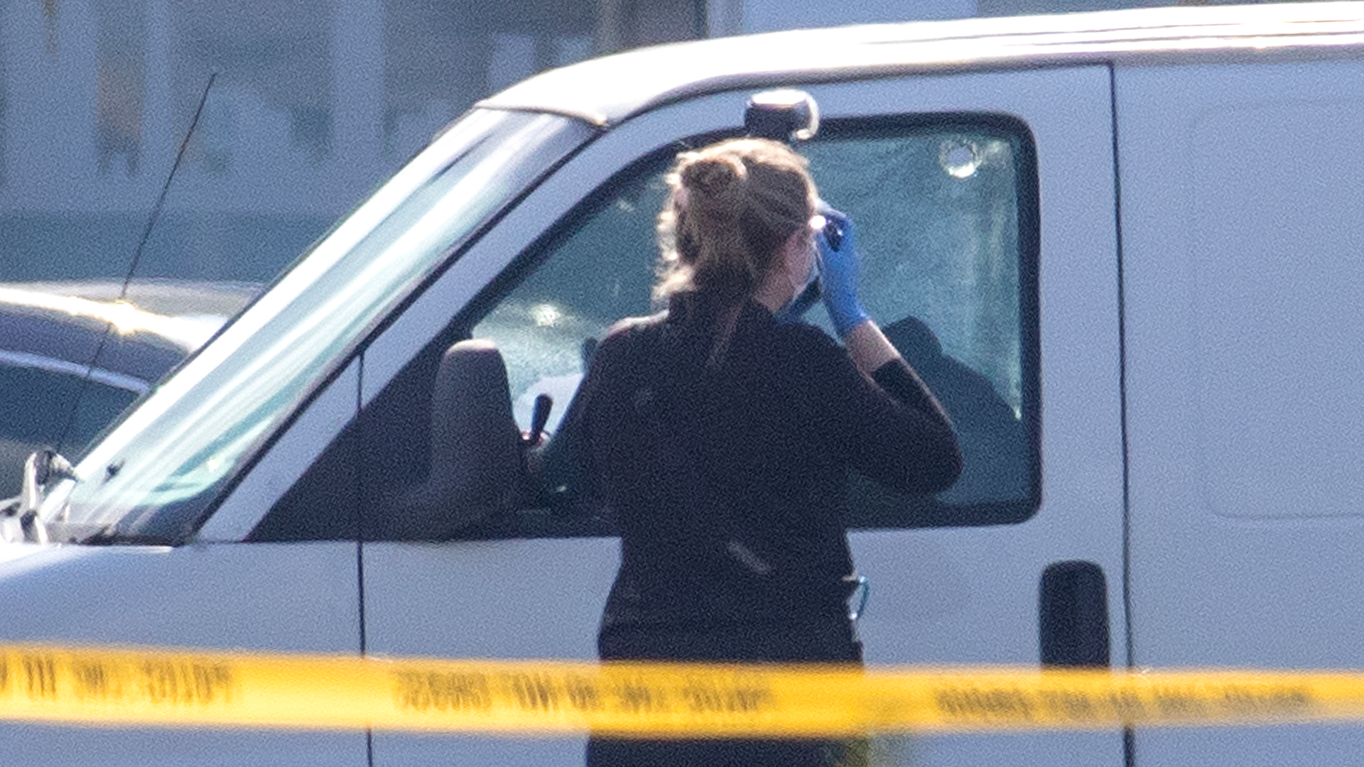 Bullet holes are visible as a coroner's official takes photos on Sunday, Jan. 22, 2023, in Torrance, California. Police say a man in a white van is connected to Saturday night's Lunar New Year mass shooting in Monterey Park. Torrance SWAT officers surrounded the van as the driver appeared slumped over the wheel.