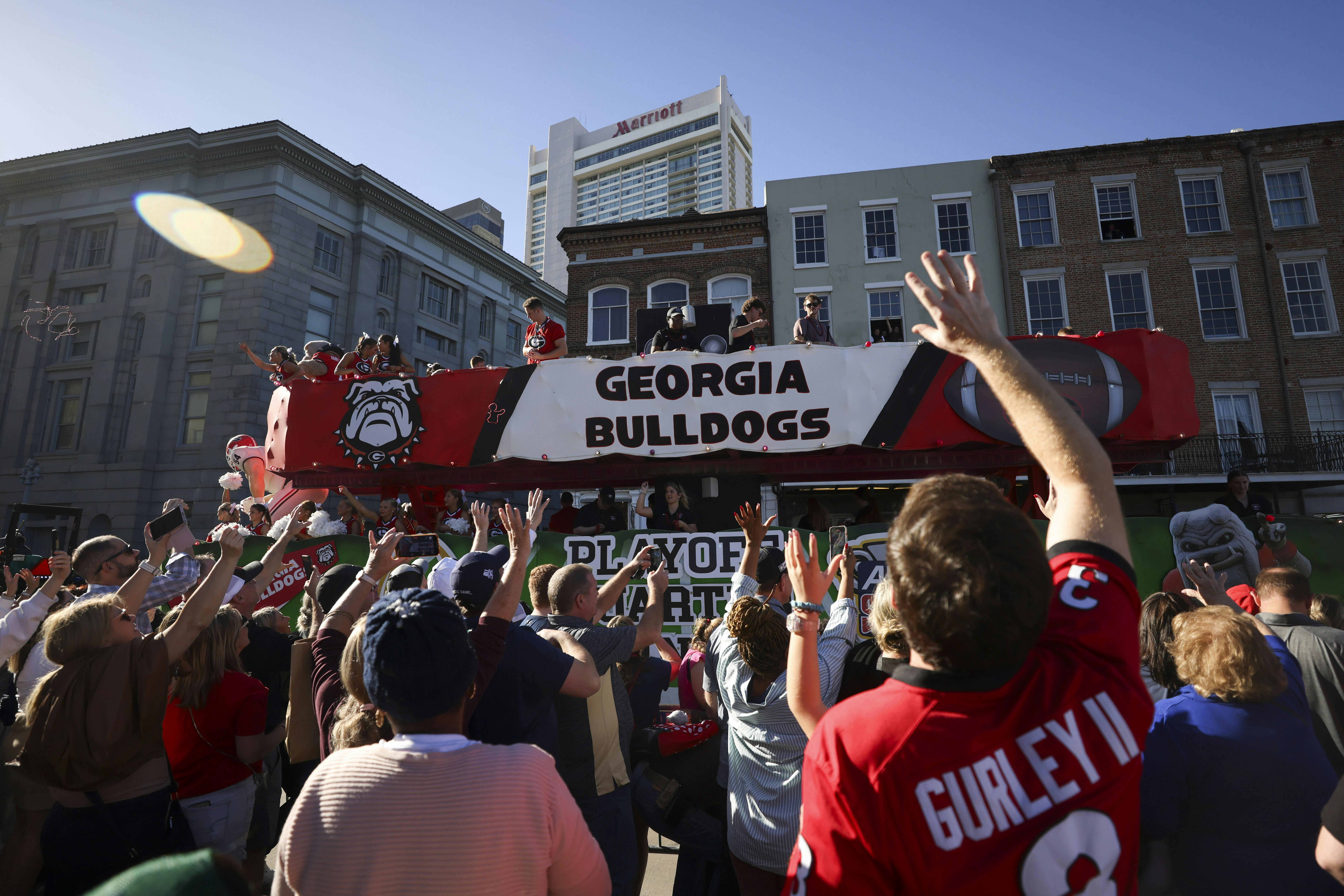 Georgia cheerleaders throw beads to fans as the Georgia float travels down Decatur Street during the Allstate Sugar Bowl New Year&rsquo;s Eve Parade, Tuesday, Dec. 31, 2024, in New Orleans.