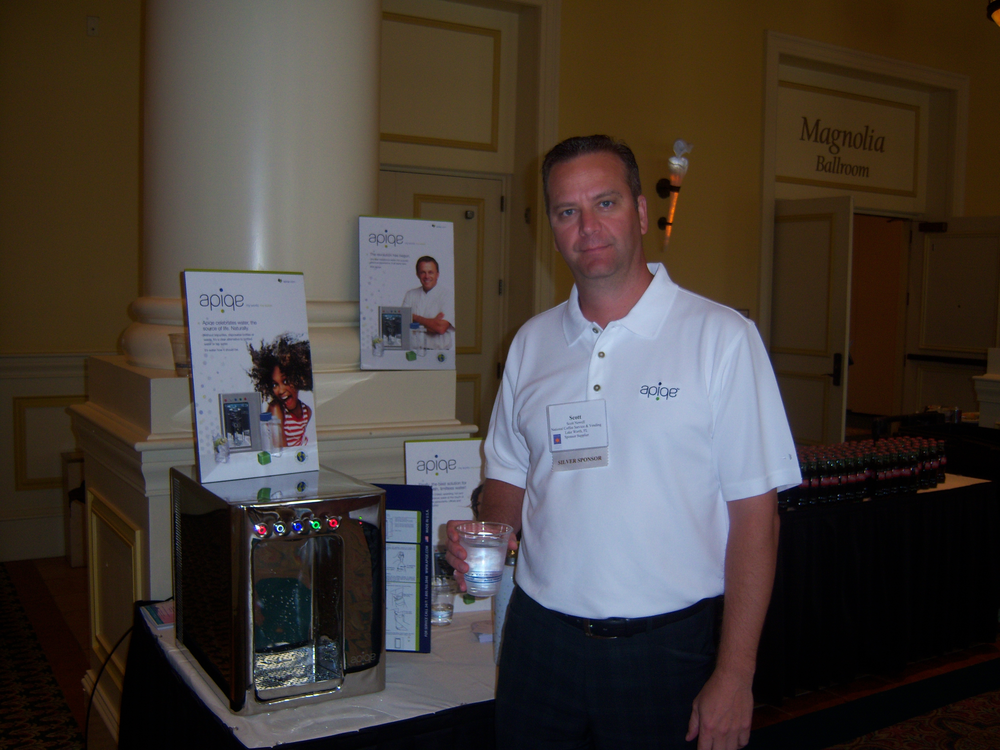 Scott Newell of Apiqe serves attendees water from the countertop water purification system.