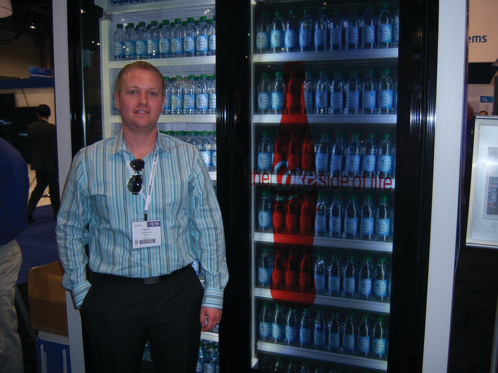 Keith Wentzell of Aramark Refreshment Services examines a transparent video display on a beverage cooler from LG Solutions during the Digital Signage Expo in Las Vegas.