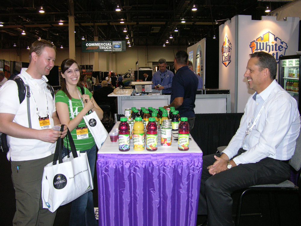 David and Kara Leighton of Quality Vending Systems, left, talk to Ron Moulden of Florida's Natural Growers, right, about Florida's Natural juice products.