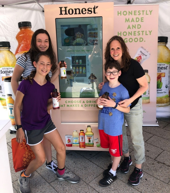 A family checks out the Honest 'Up Your Impact' vending machine at Chelsea Piers in New York City.