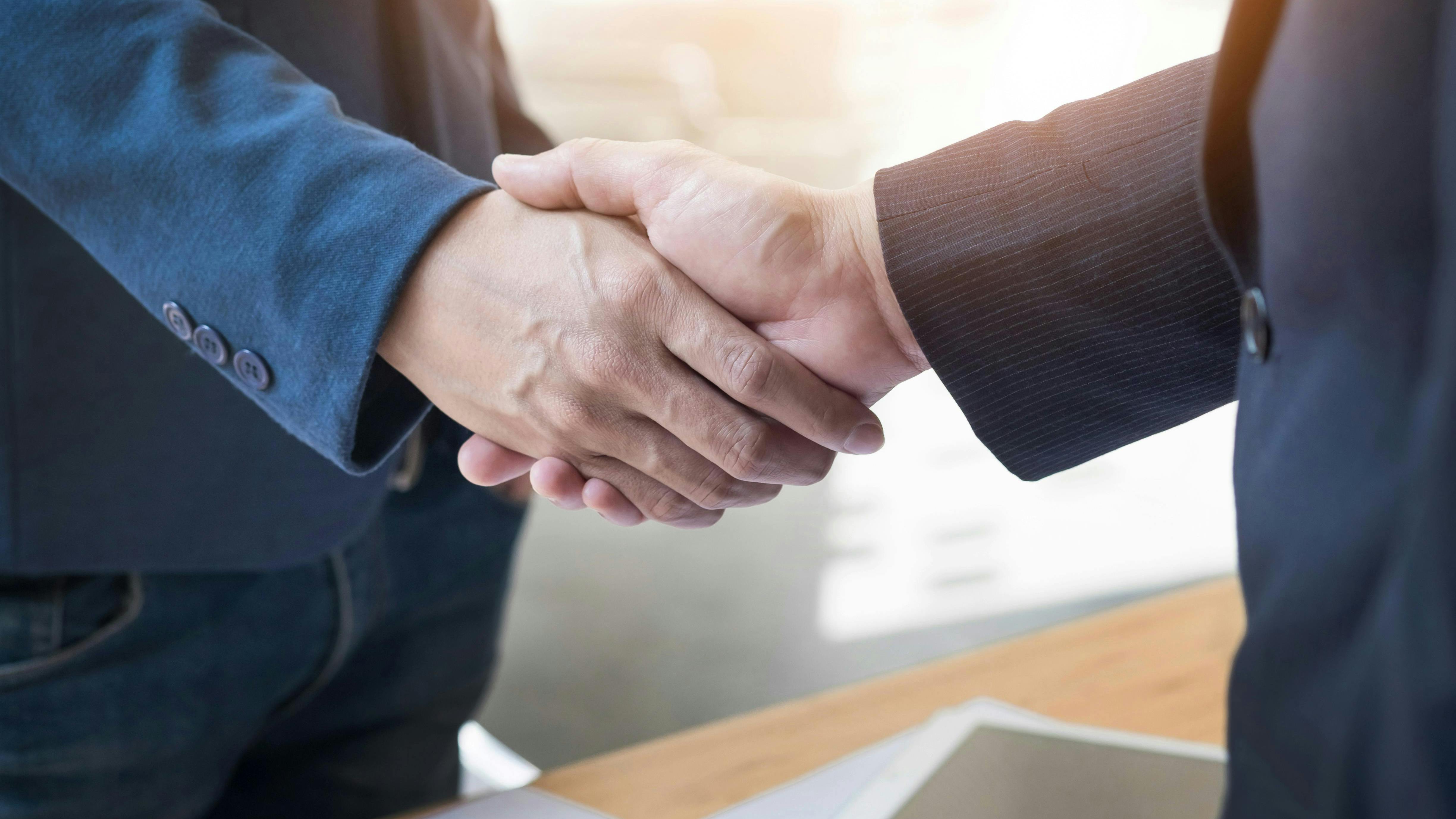 two men shaking hands merger acquisition