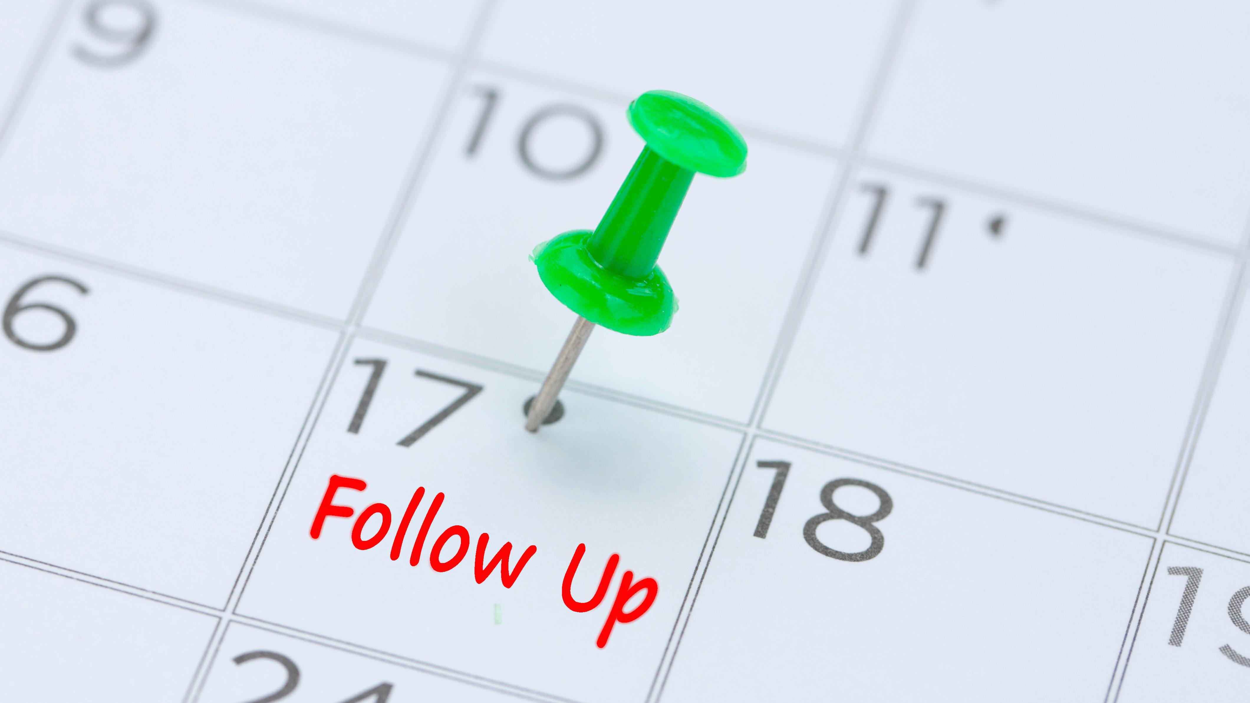 Follow Up written on a calendar with a green push pin to remind you and important appointment