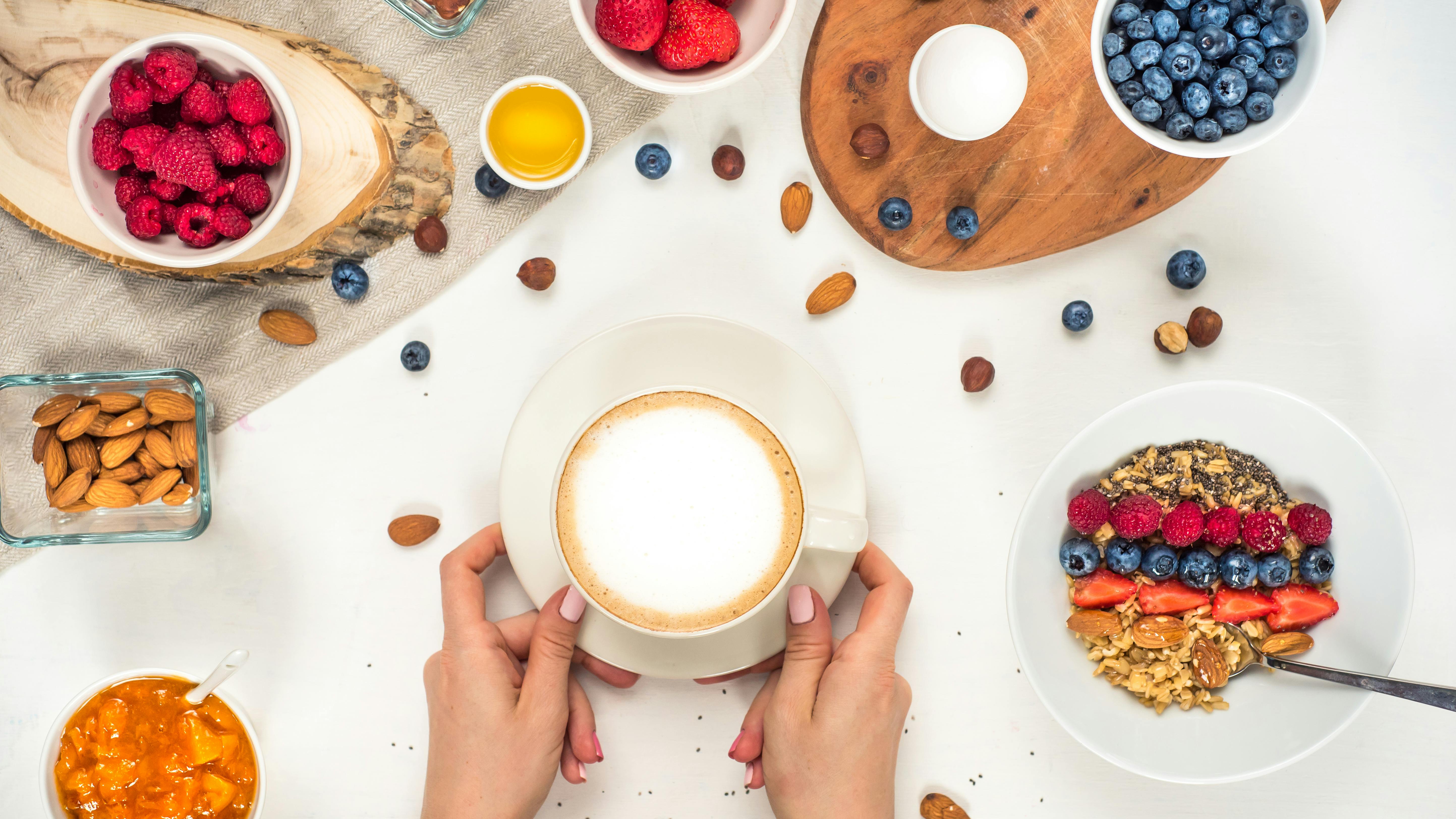 breakfast background with oatmeal coffee, berries, egg, nuts, coffee