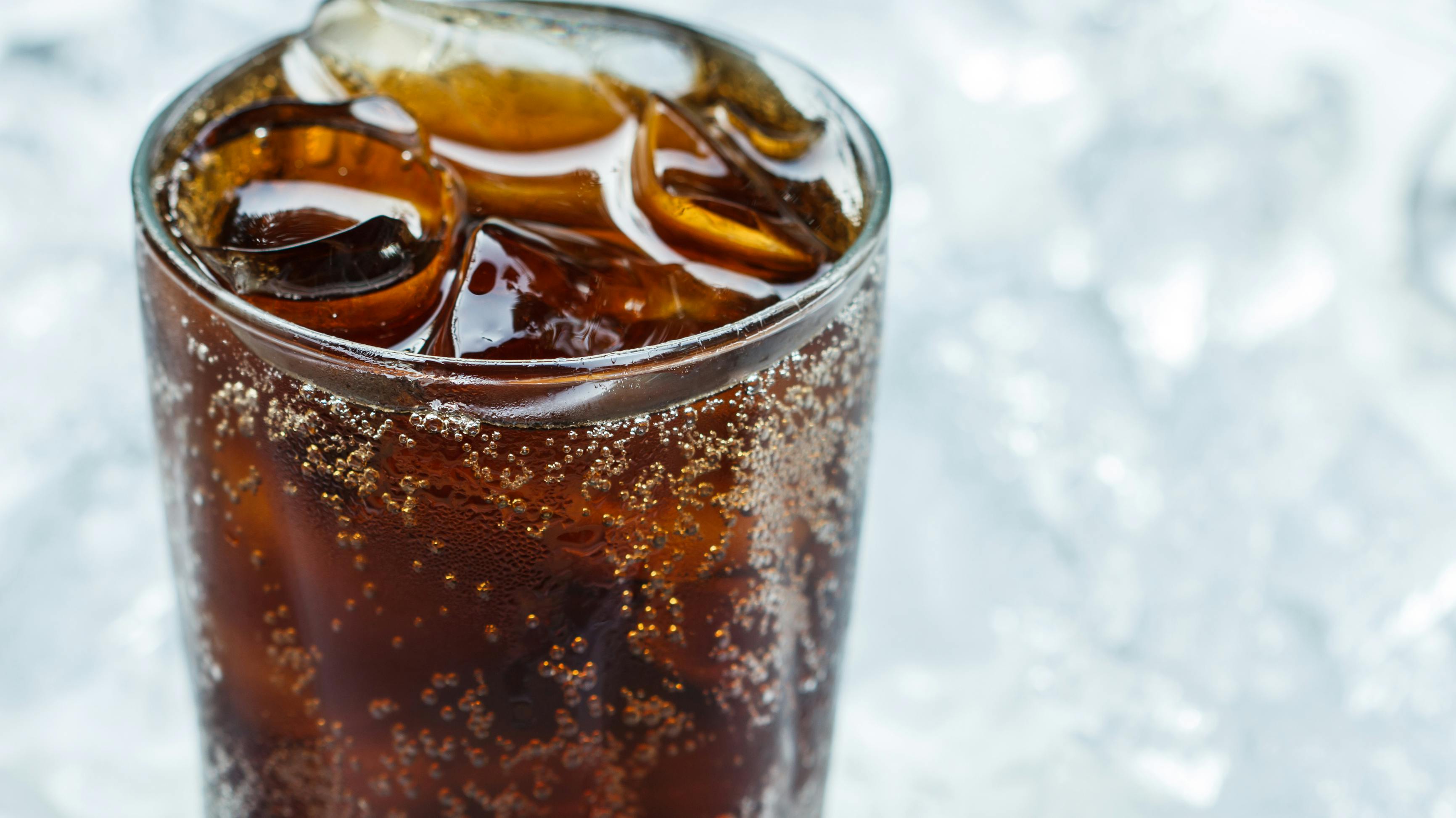 cola in a glass in front of ice