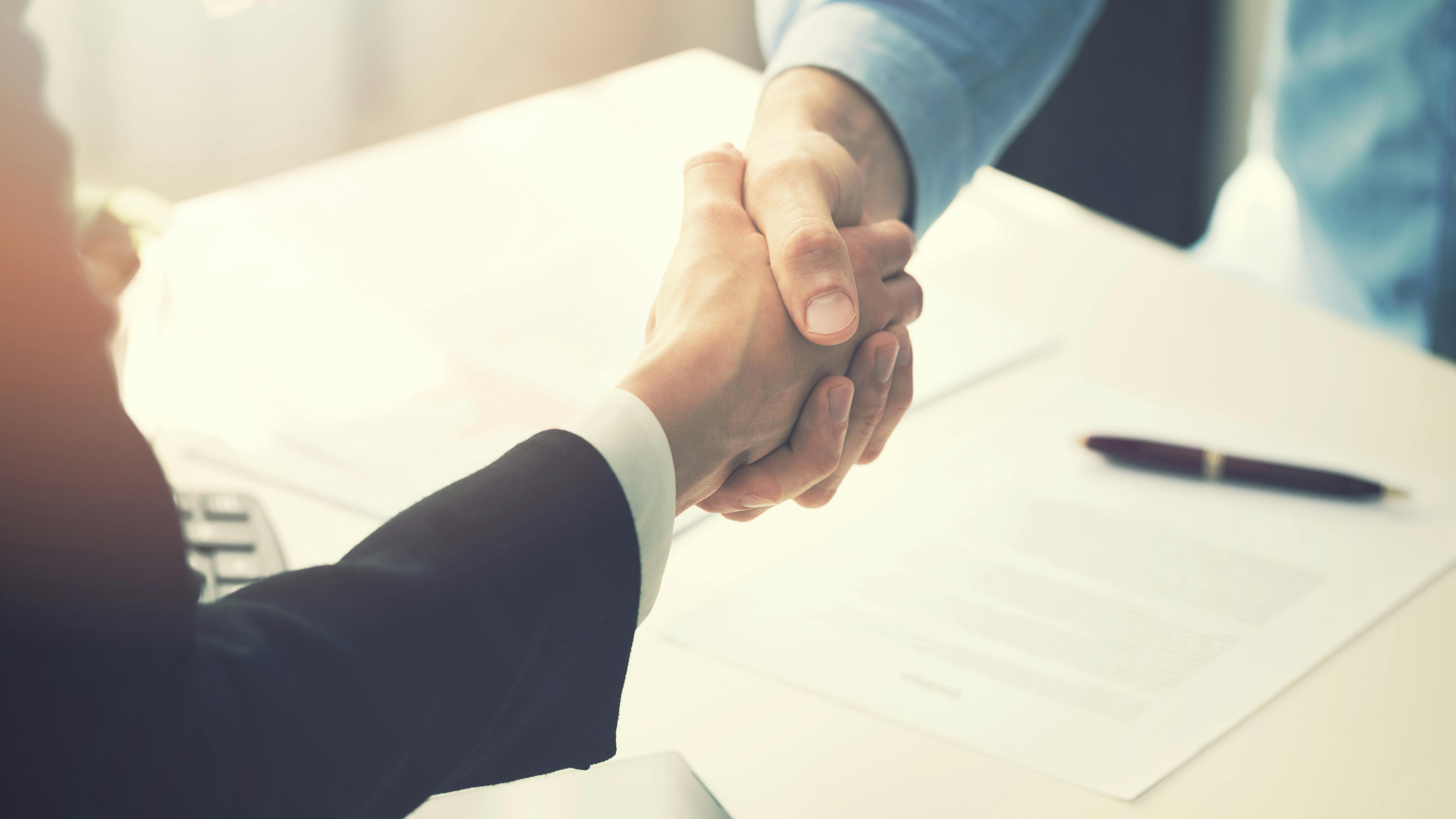 handshake across desk dreamstime_xxl_94512900