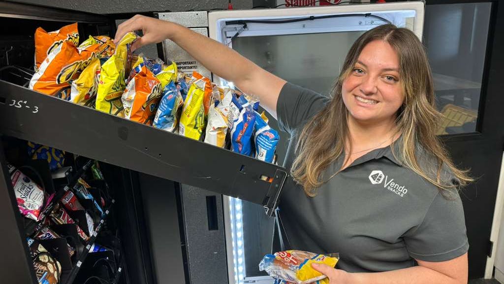 Mariah Silva, a partner at Vendo Snacks, restocks a client location. vending convenience services